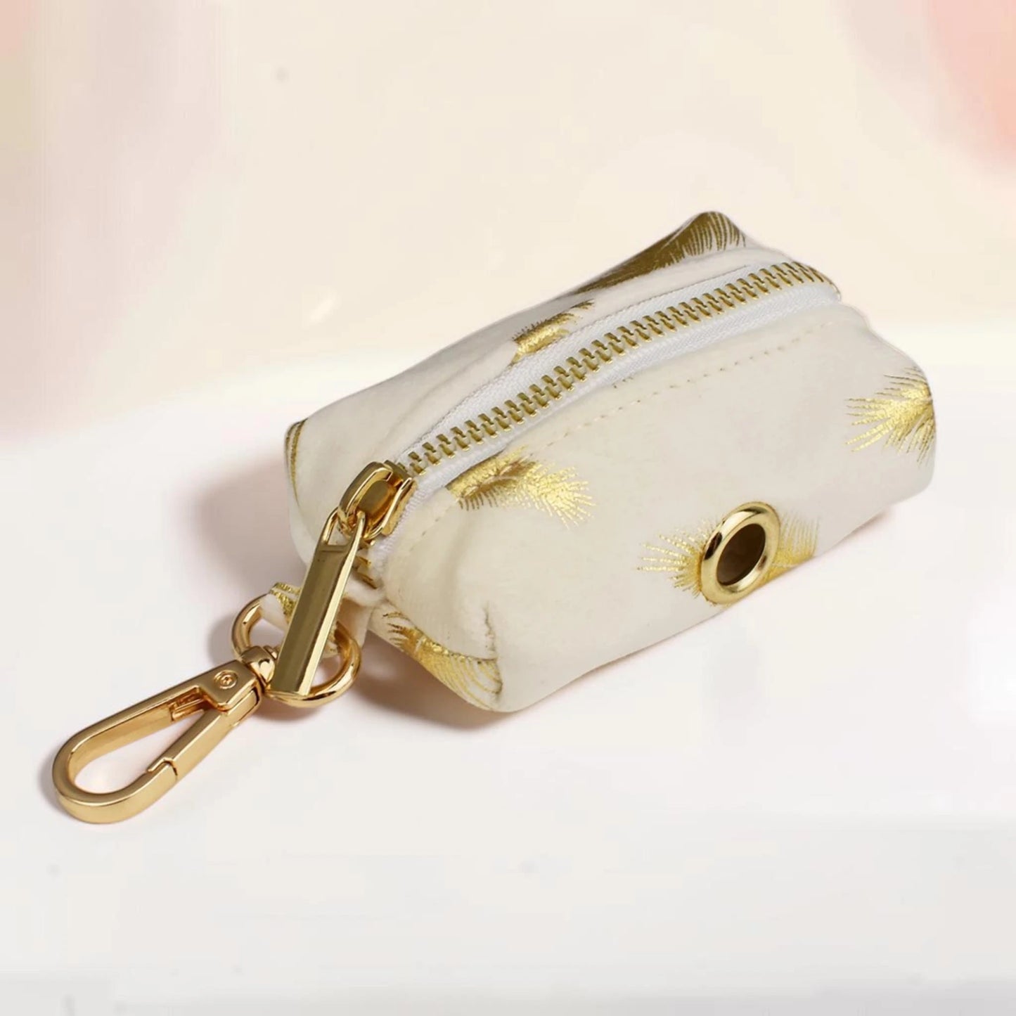 Golden feather dog poop bag holder with a gold zip and clip
