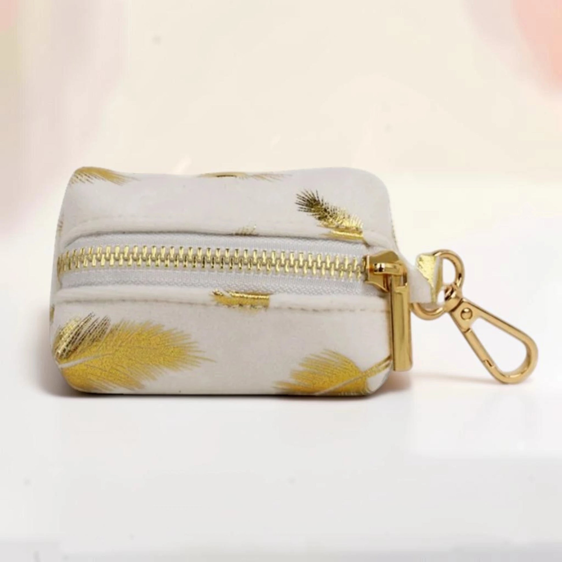 Golden feather dog poop bag holder with a gold zip and clip