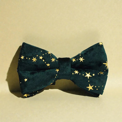 Green bow tie with gold star pattern on a beige background