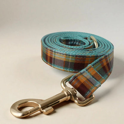 Plaid dog leash with gold clasp on a beige background