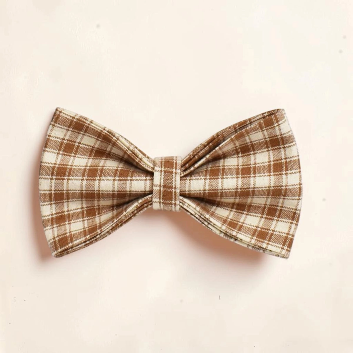 A dog bow tie with a brown and cream plaid pattern.