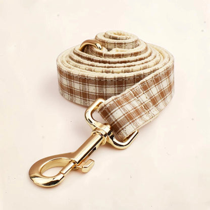 Heritage check dog lead with a brown and beige plaid pattern and shiny gold-tone metal hardware.