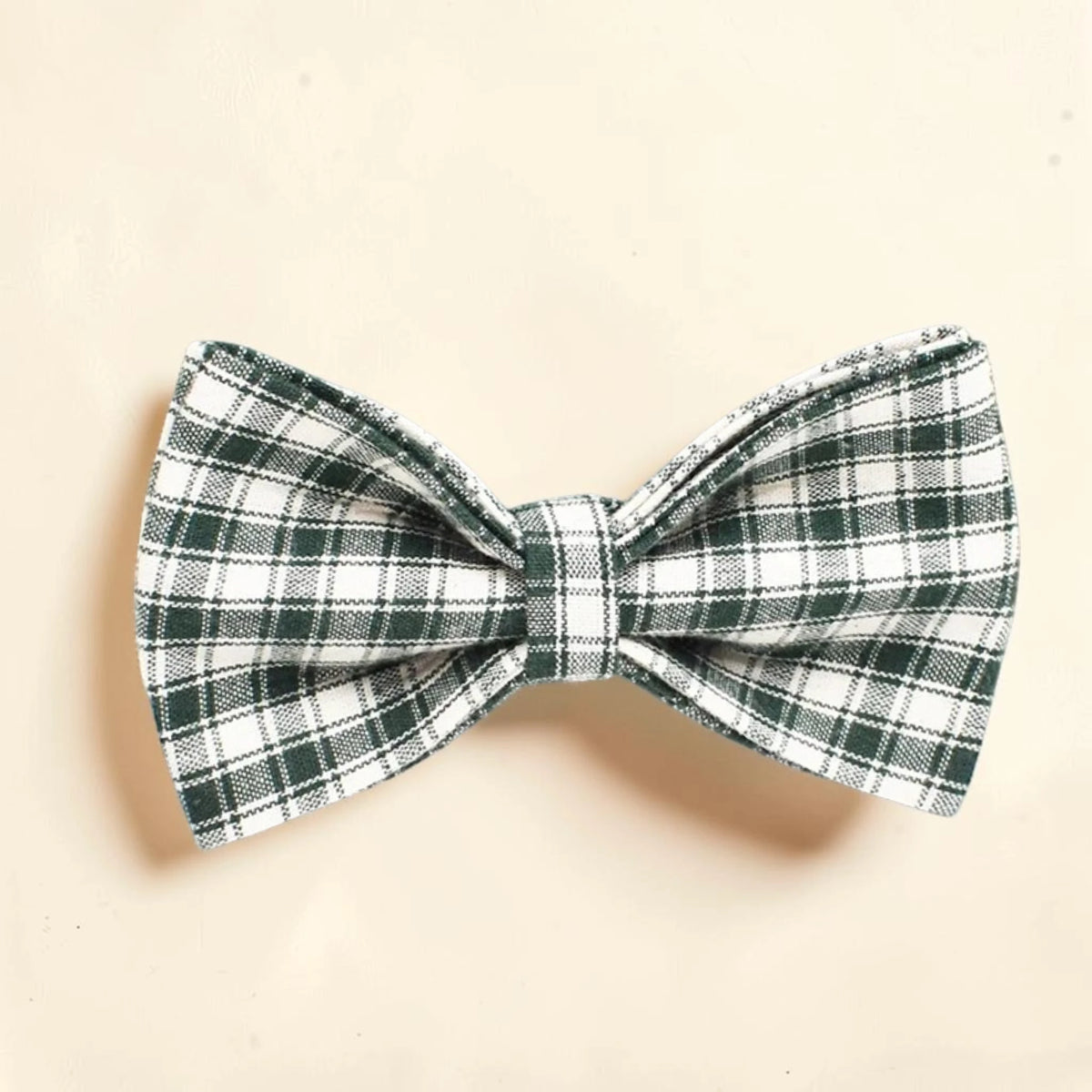 A dog bow tie with a green and white plaid pattern.