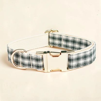 A dog collar with a green and white plaid pattern and a gold-tone metal buckle and D-ring.