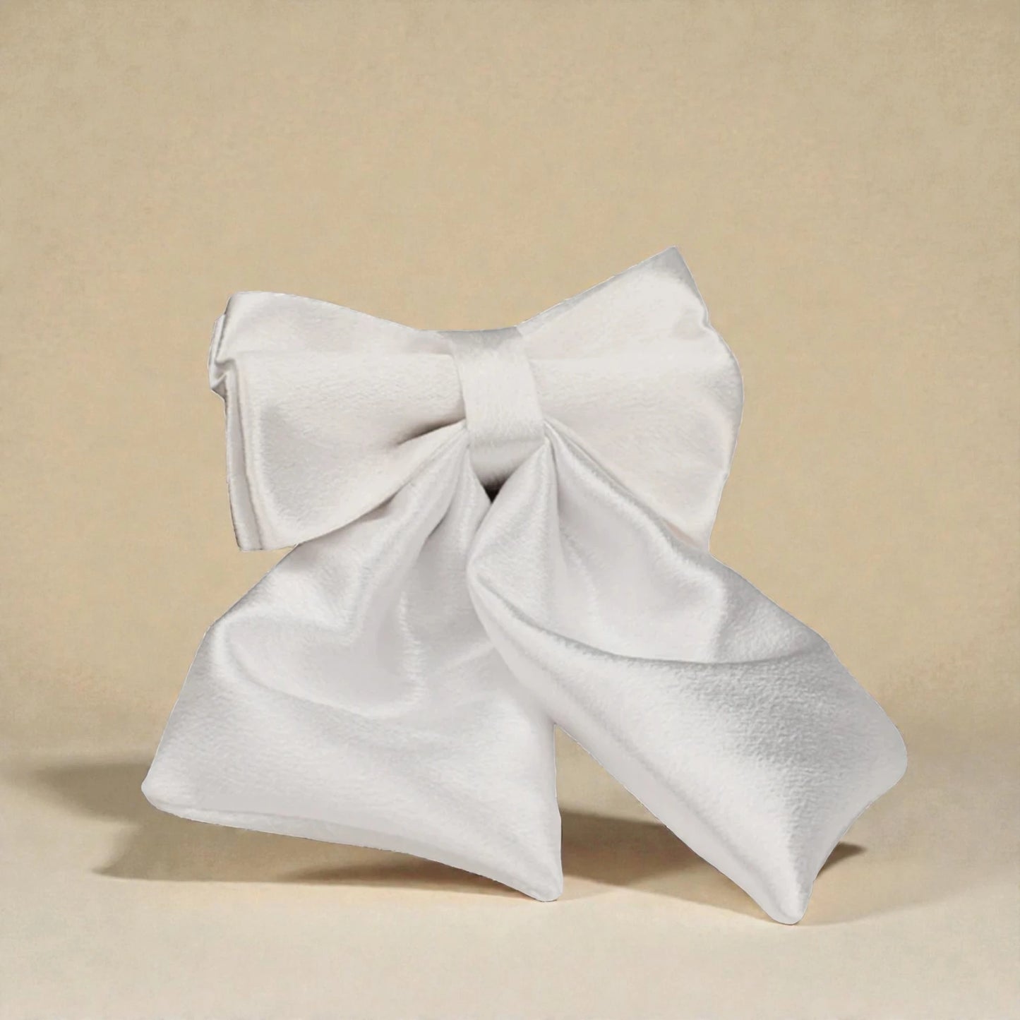 Ivory decorative dog bow on a beige background