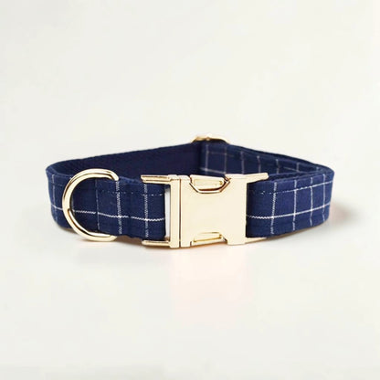 Navy check dog collar with a gold buckle on a light beige background