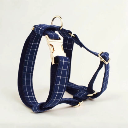 Navy check dog harness with gold hardware on a light background