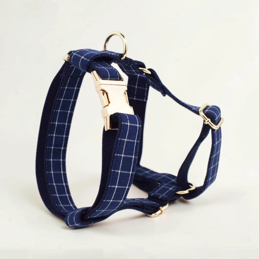 Navy check dog harness with gold hardware on a light background