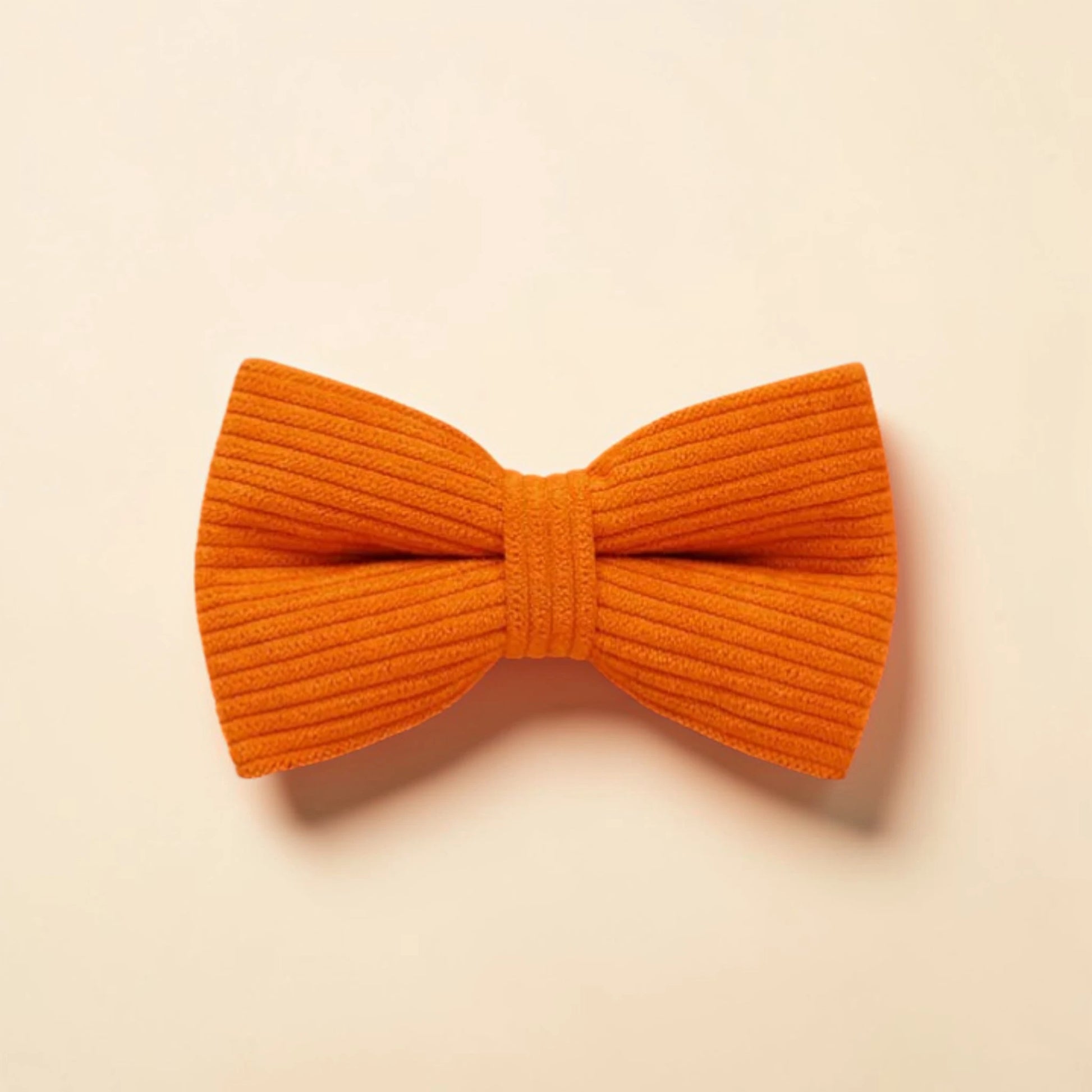 Orange corduroy bow tie on a beige background