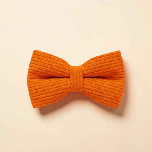 Orange corduroy bow tie on a beige background