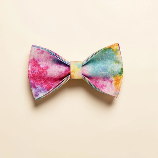 Colourful tie-dye dog bow tie on a beige background