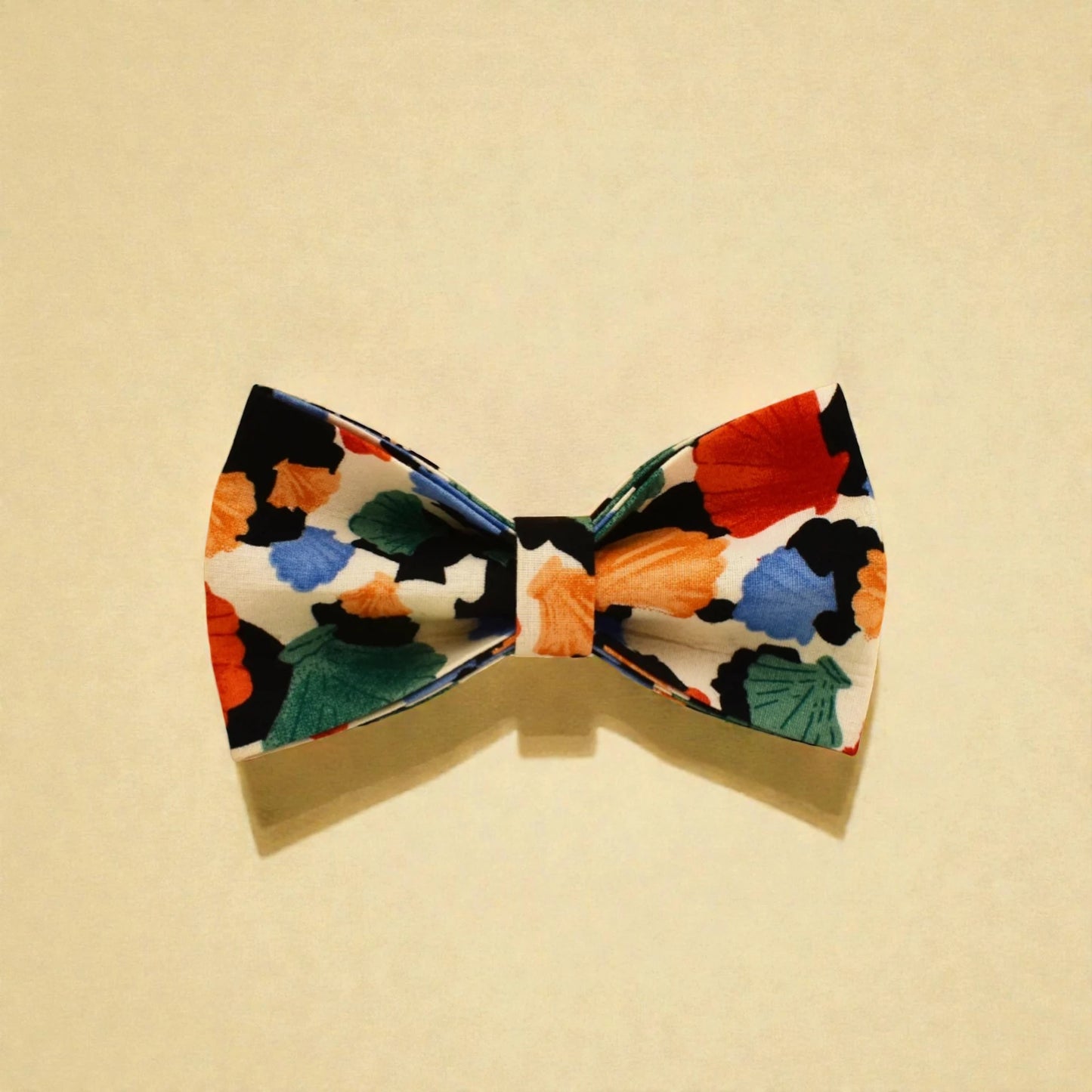 Colourful dog bow tie with floral pattern on a beige background