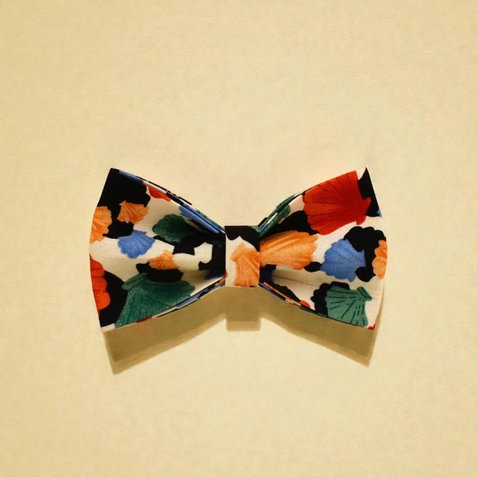 Colourful dog bow tie with floral pattern on a beige background