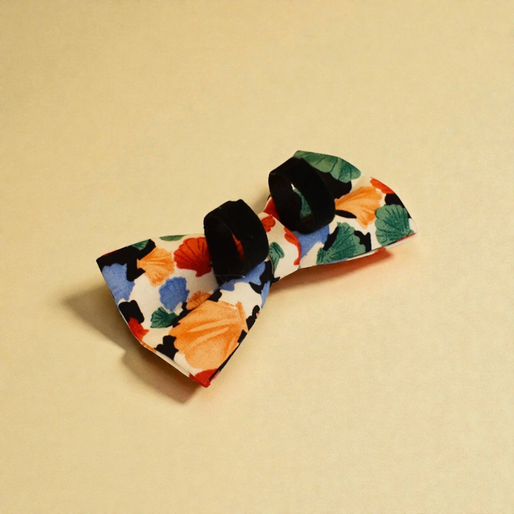 Detachable dog bow tie accessories on a beige background