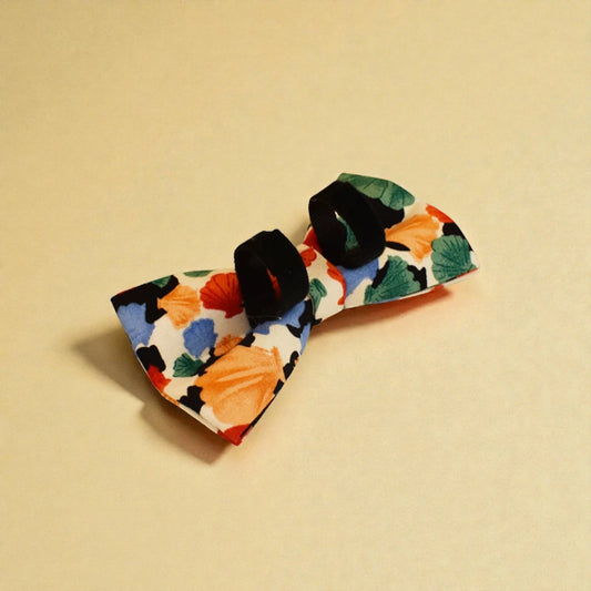 Detachable dog bow tie accessories on a beige background