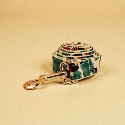 Dog lead with colourful pattern and gold clasp on beige background