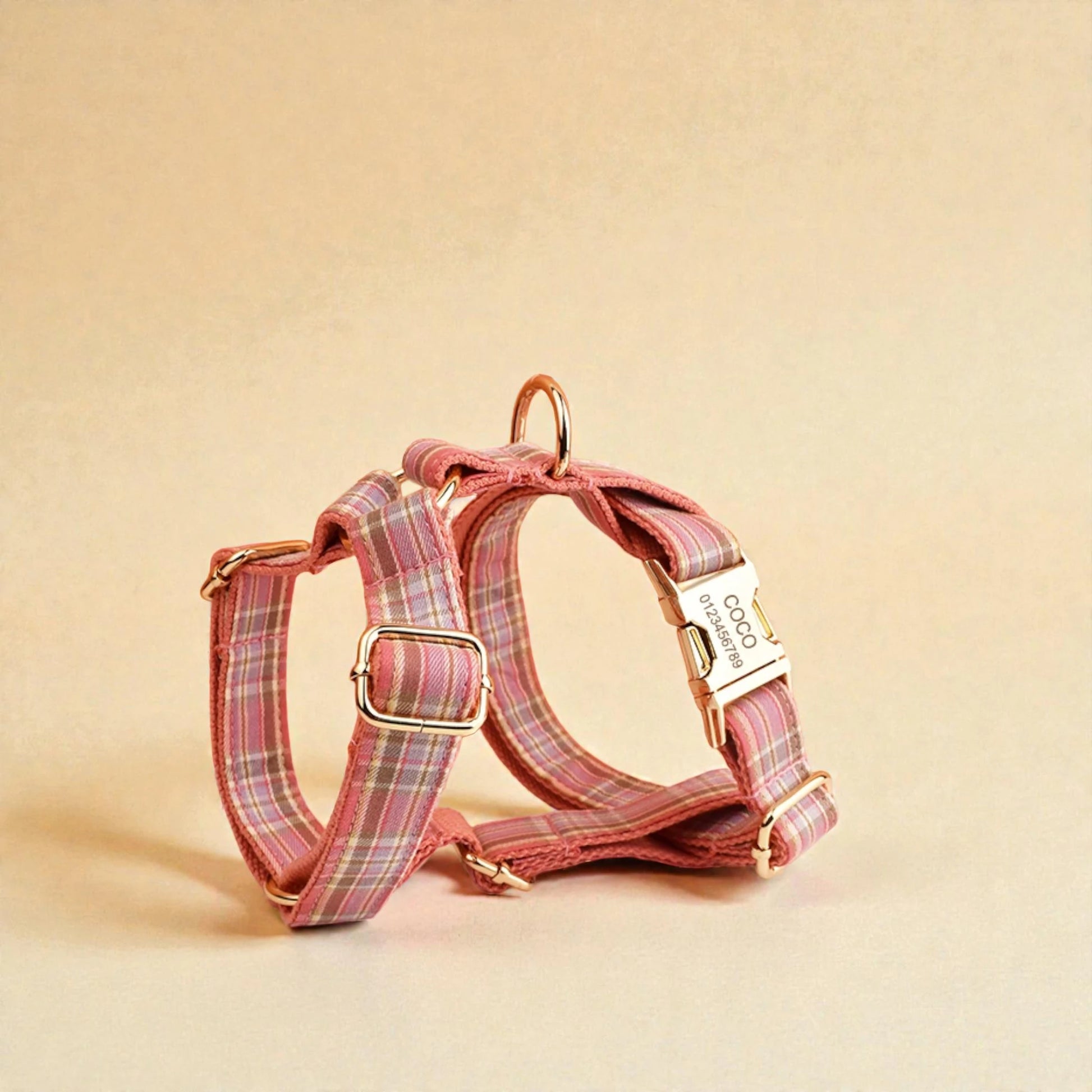 Pink plaid personalised dog harness on a beige background
