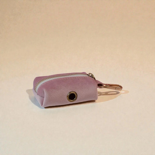 Pink dog poop bag holder with a zip on a beige background