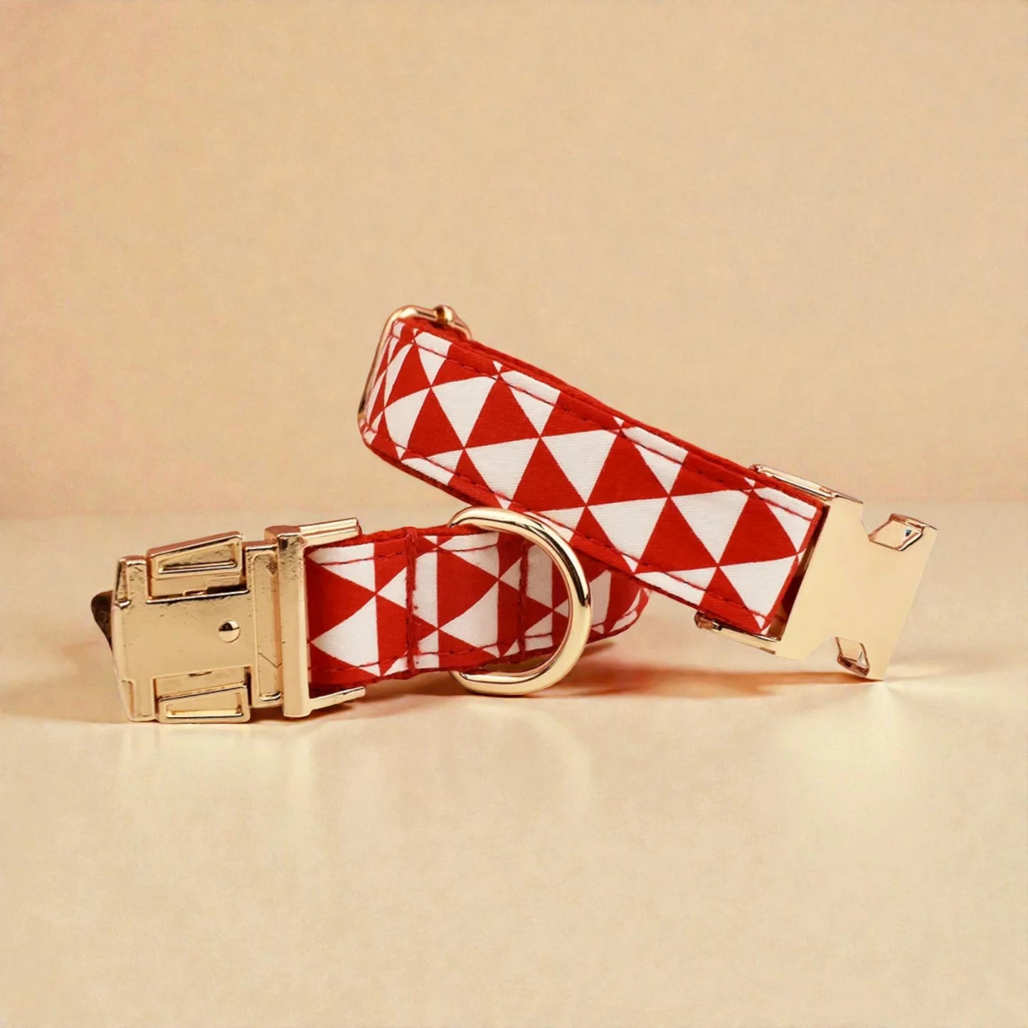 Red and white checkered dog collar with gold hardware on a beige background
