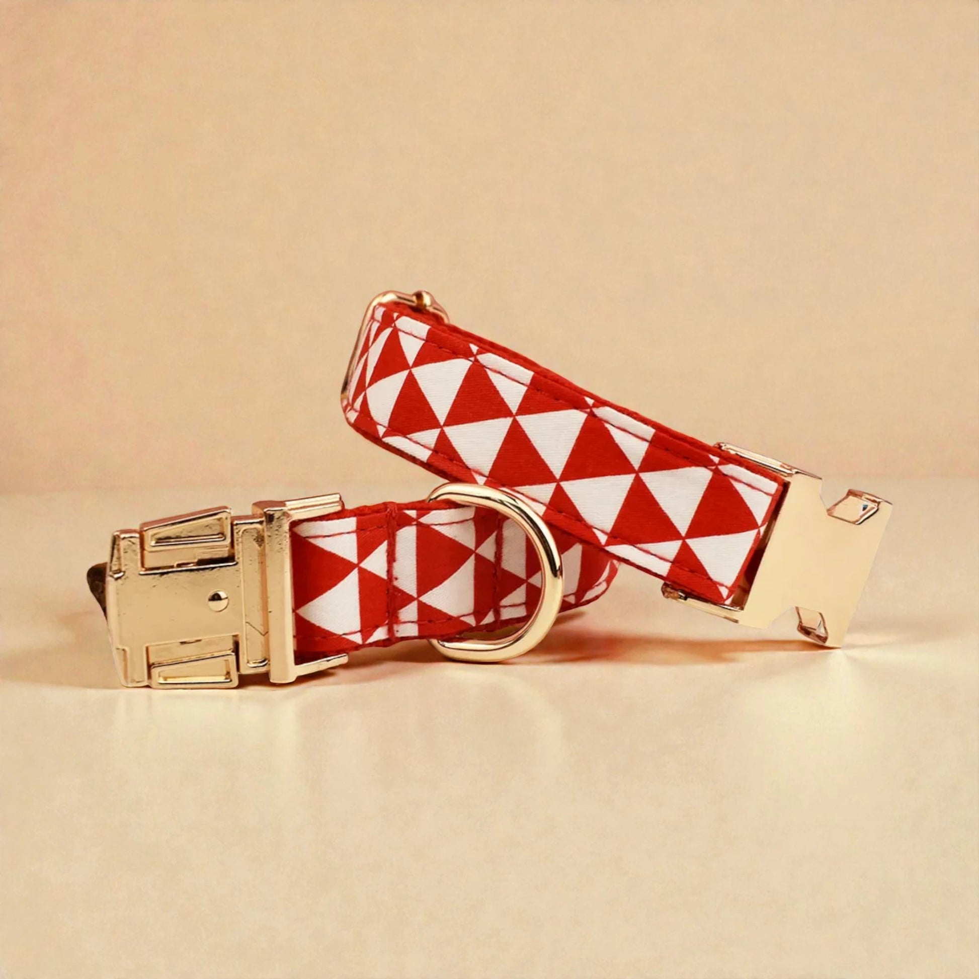Red and white checkered dog collar with gold hardware on a beige background