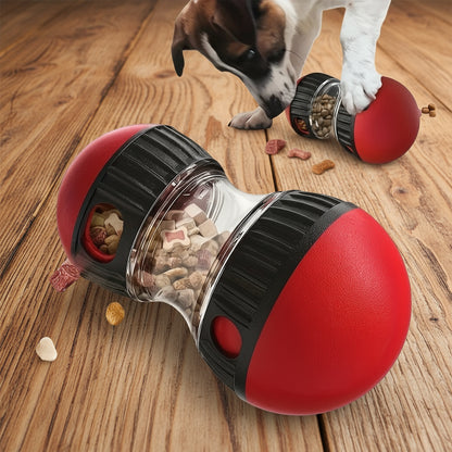 Red and black dog toy with food dispenser, dog interacting with it on a white background