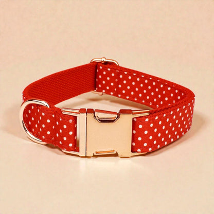 Red dog collar with white polka dots and gold buckle on a beige background