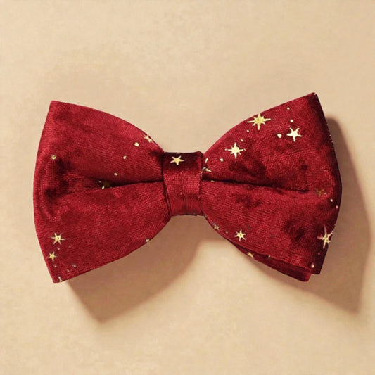 Red bow tie with gold star patterns on a beige background