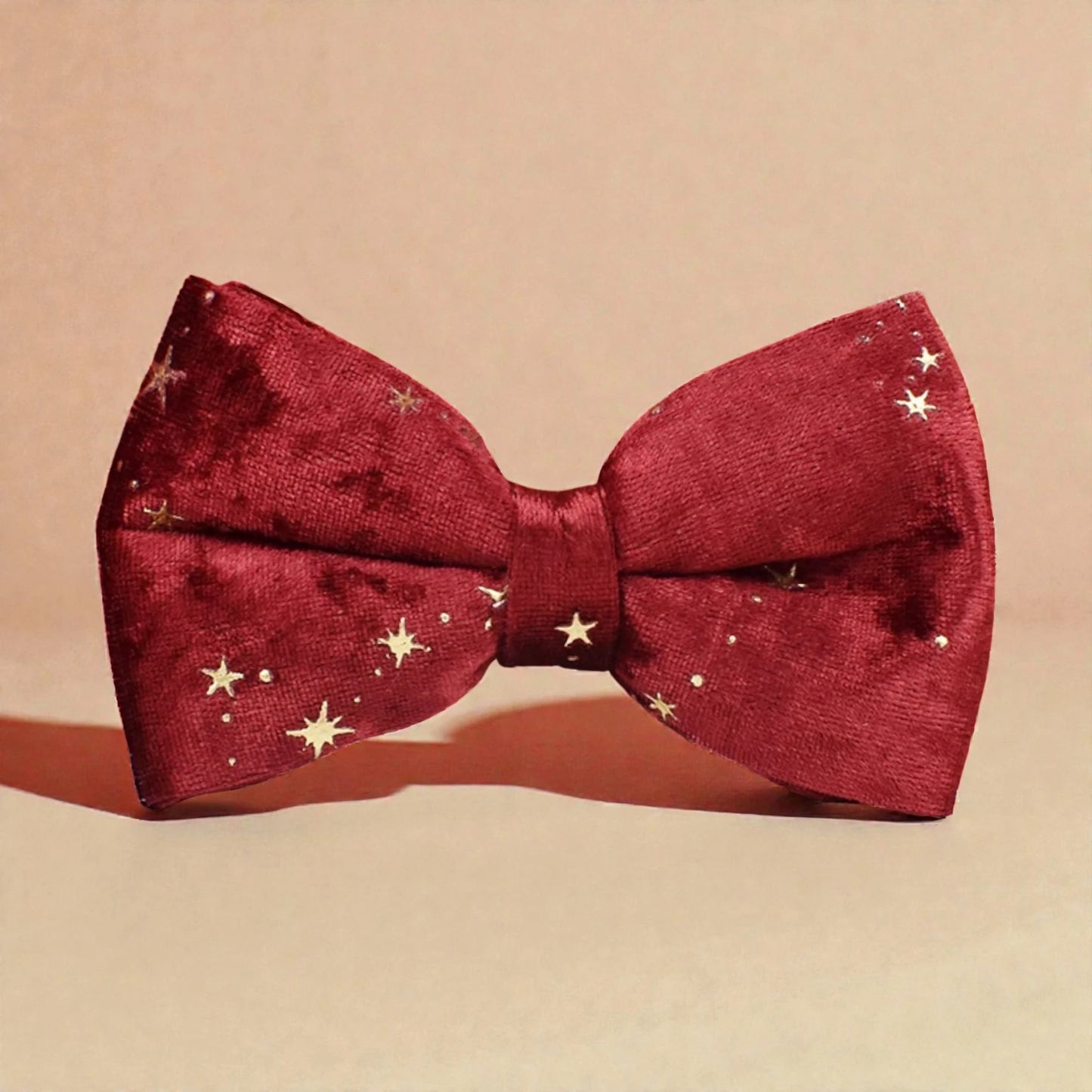 Red bow tie with gold star patterns on a beige background
