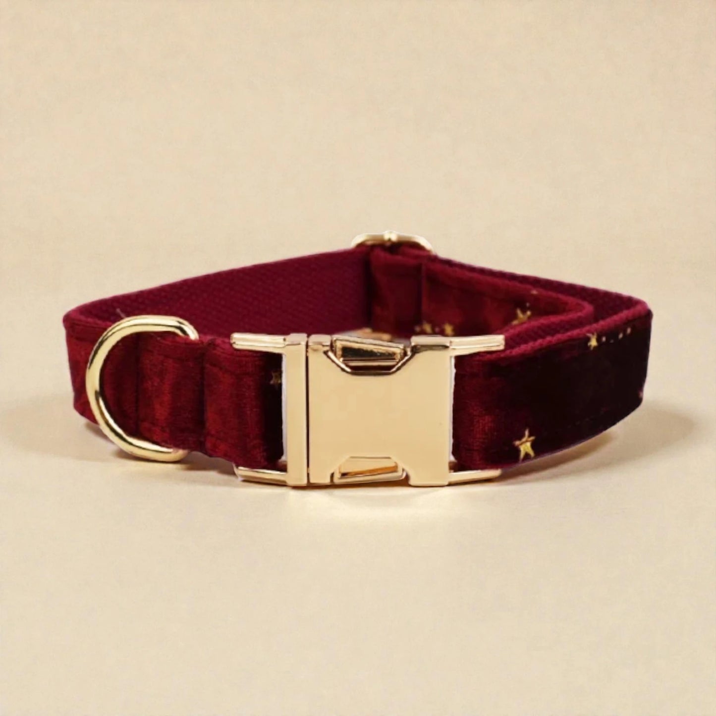Burgundy dog collar with gold buckle on a beige background