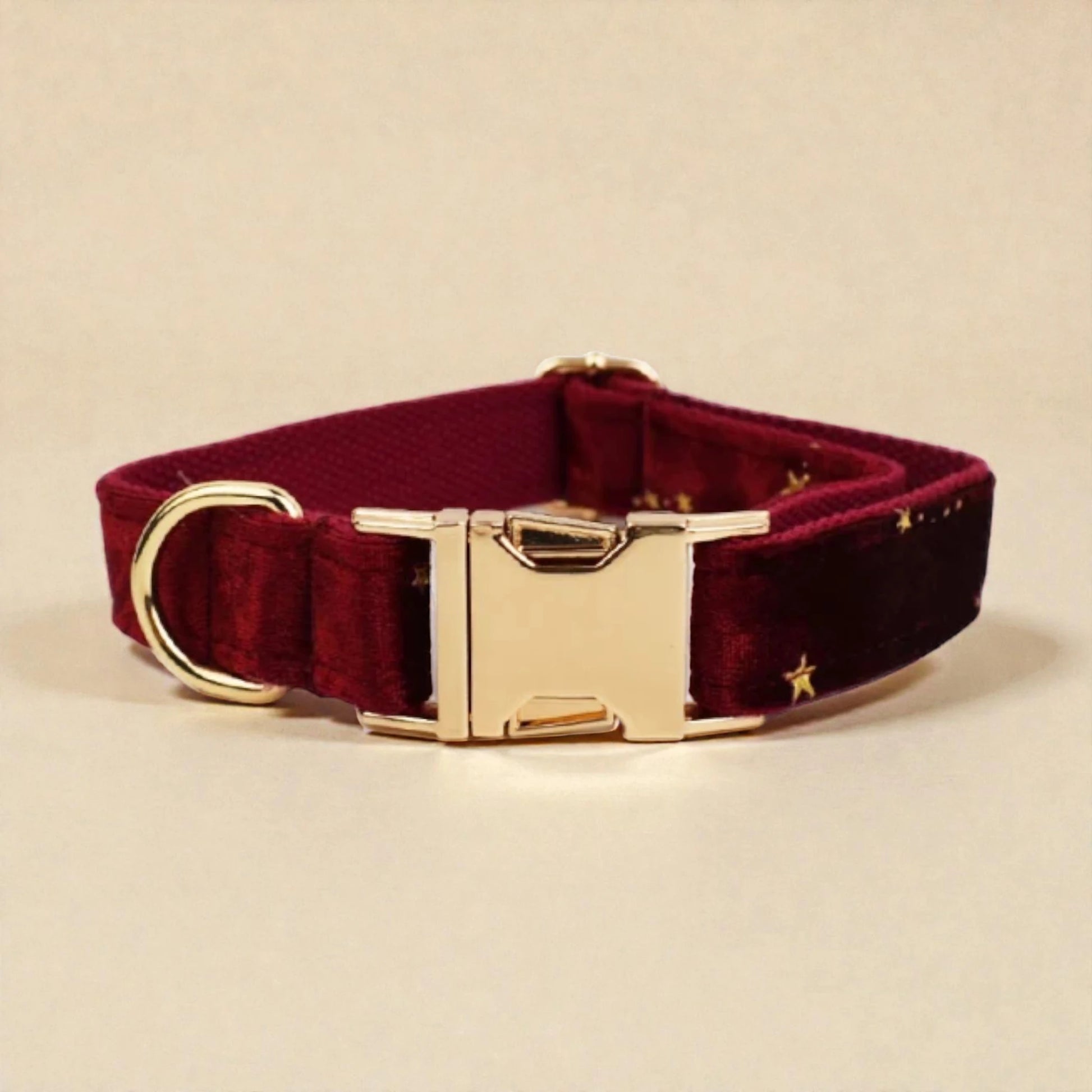 Burgundy dog collar with gold buckle on a beige background