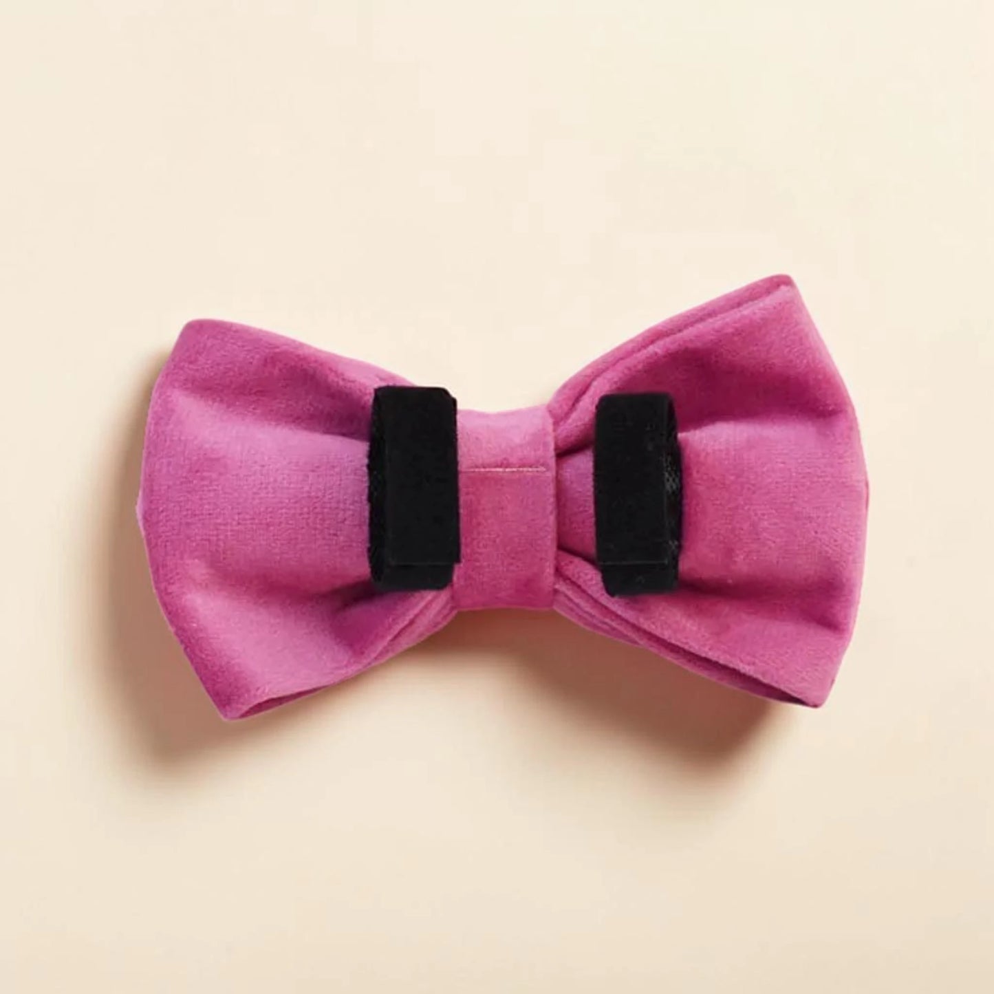 Pink detachable dog bow tie on a beige background