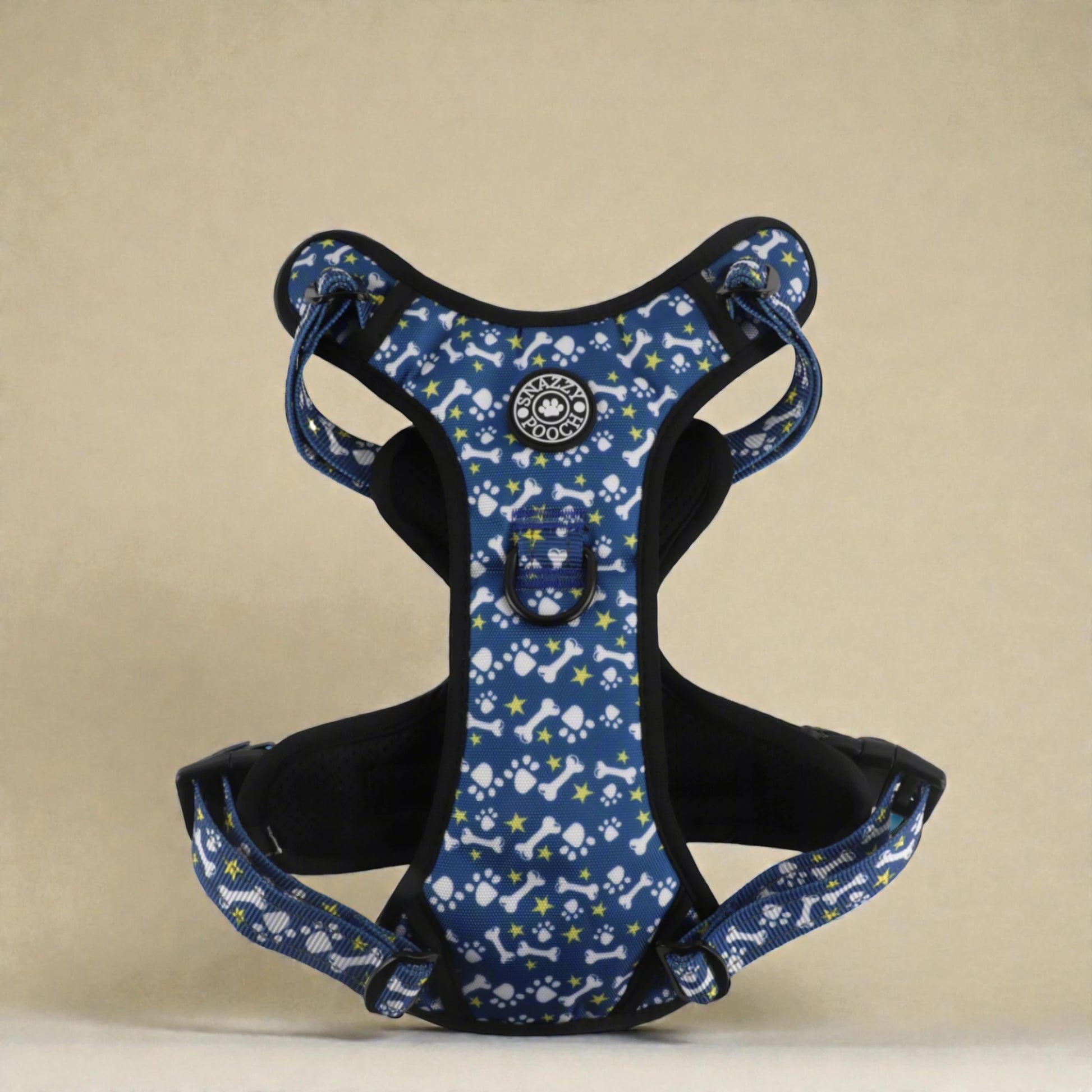 Blue dog harness with paws and bones pattern on a beige background