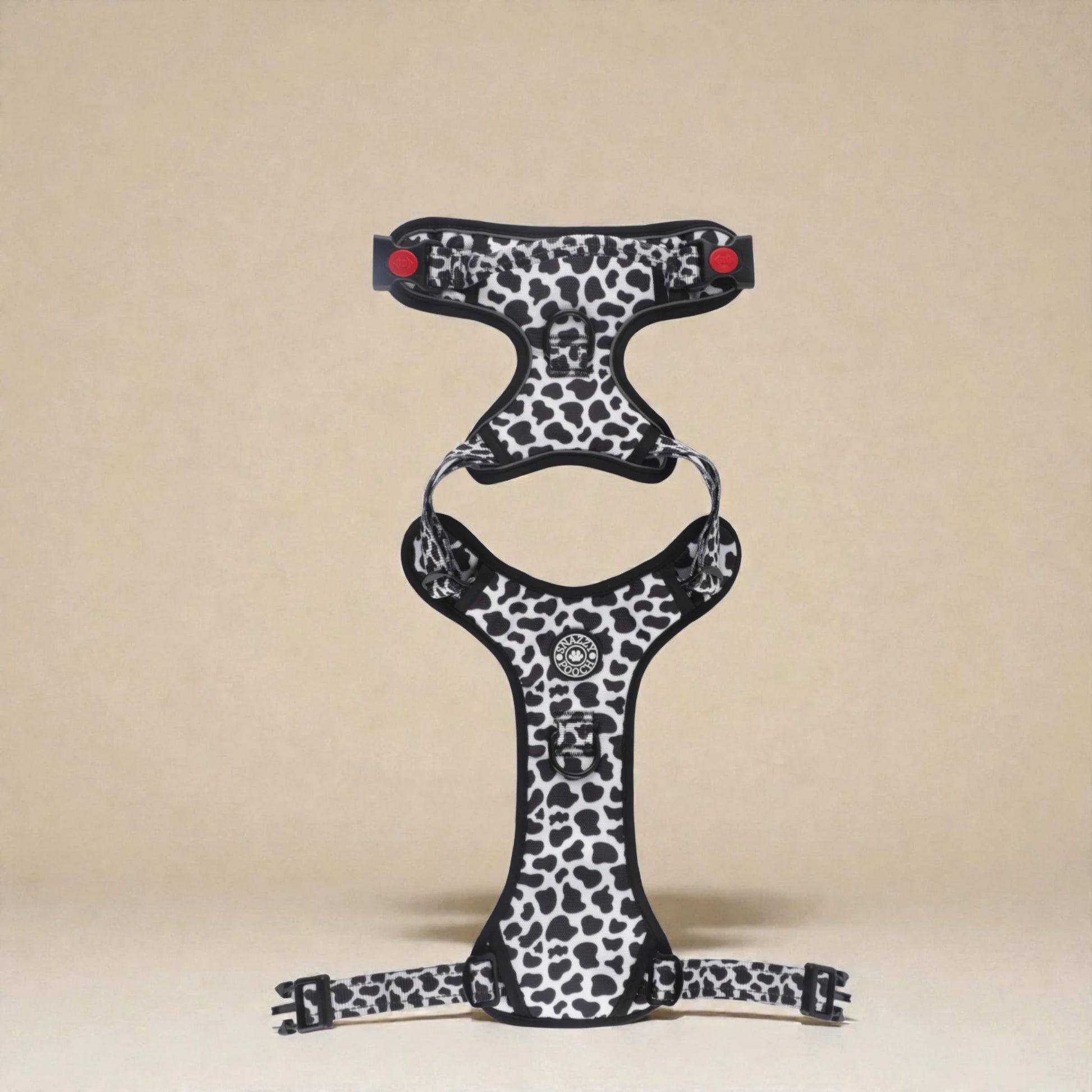 Cow print dog harness on a beige background