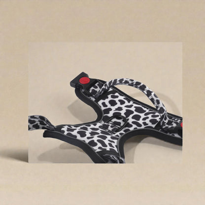 Cow print dog harness on a beige background