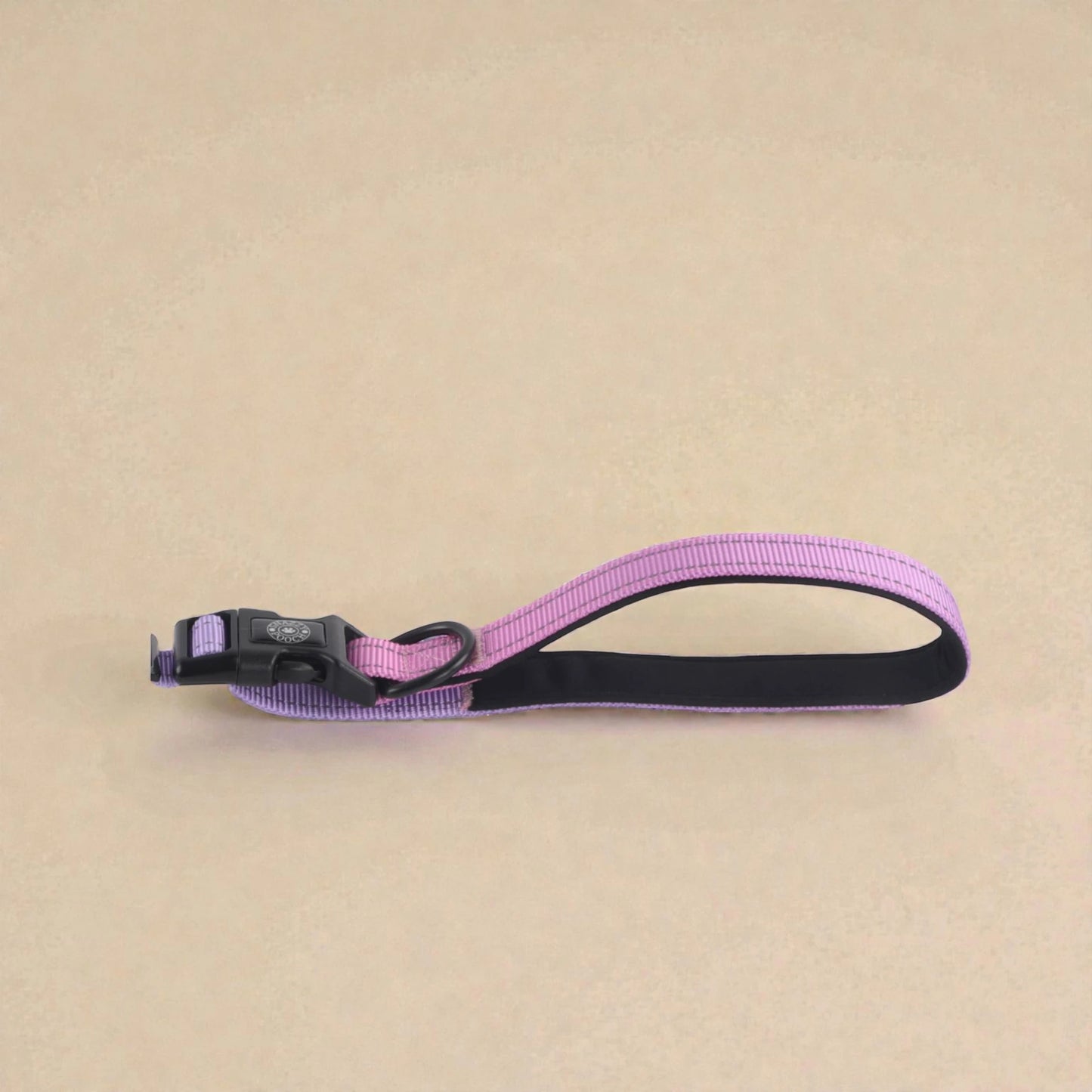 Pink and blue dog lead handle on a beige background