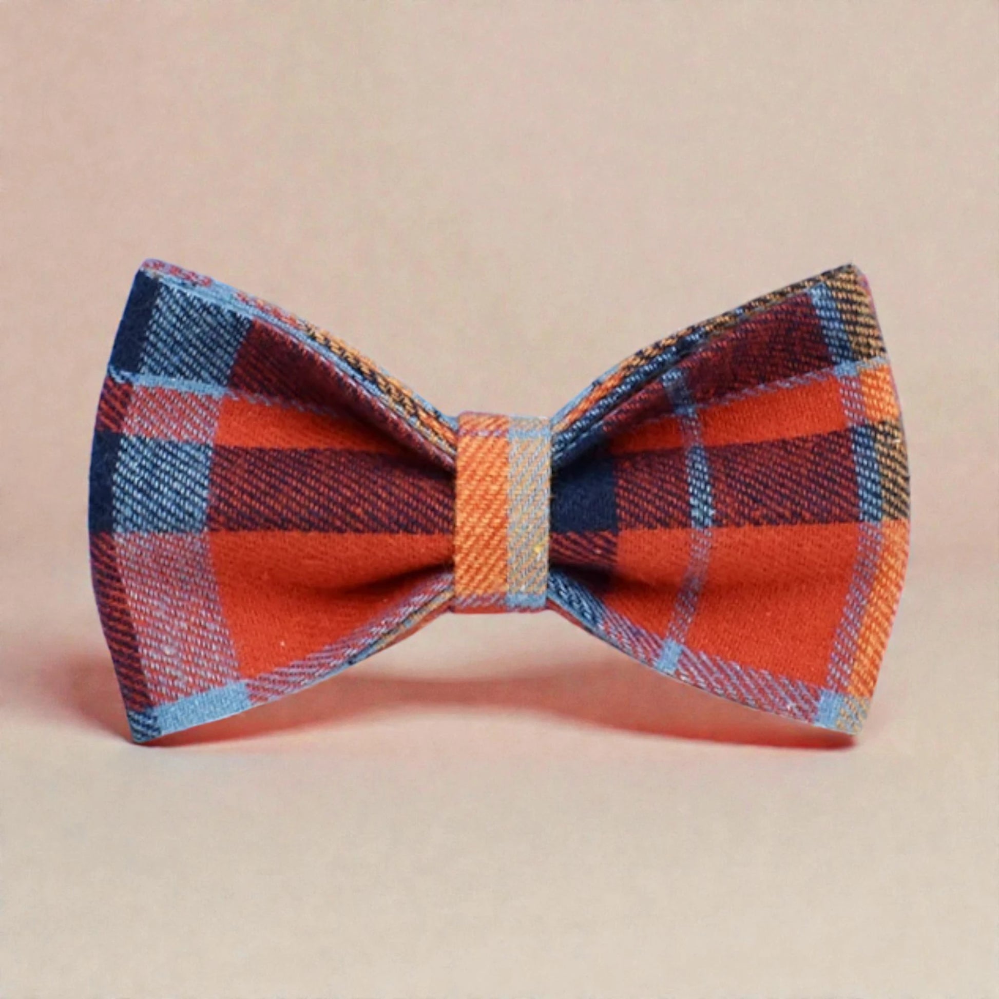 Plaid blue bow tie with red, blue, and orange pattern on a beige background