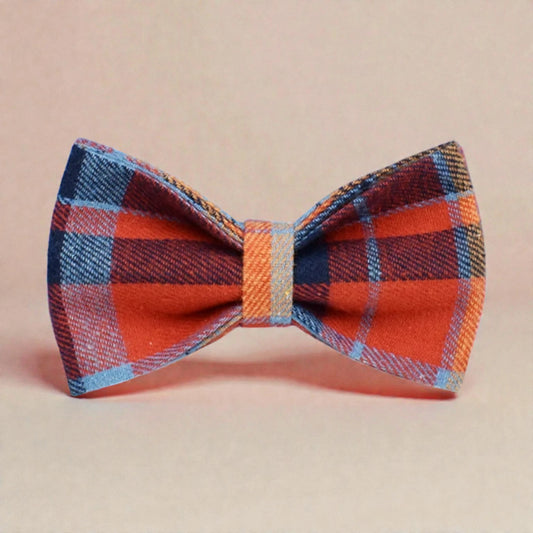 Plaid blue bow tie with red, blue, and orange pattern on a beige background