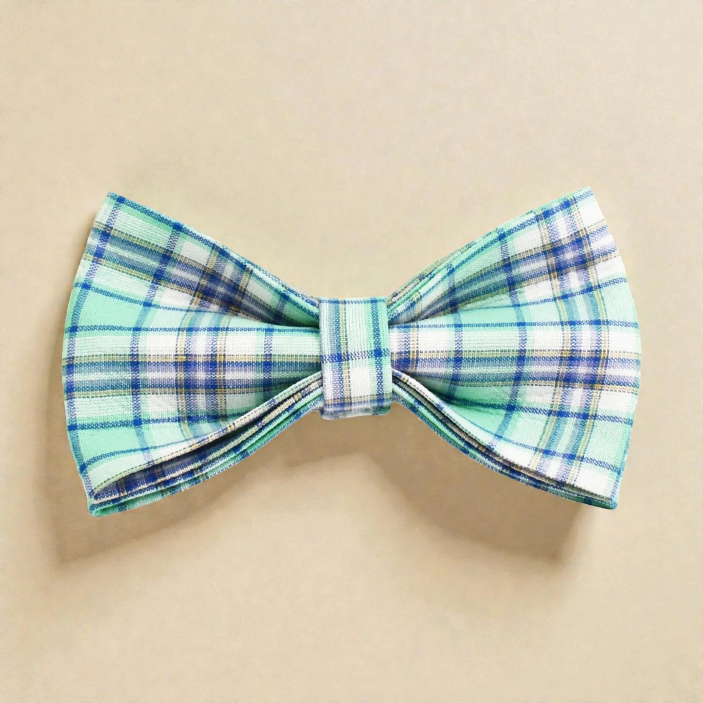 Plaid green bow tie on a beige background