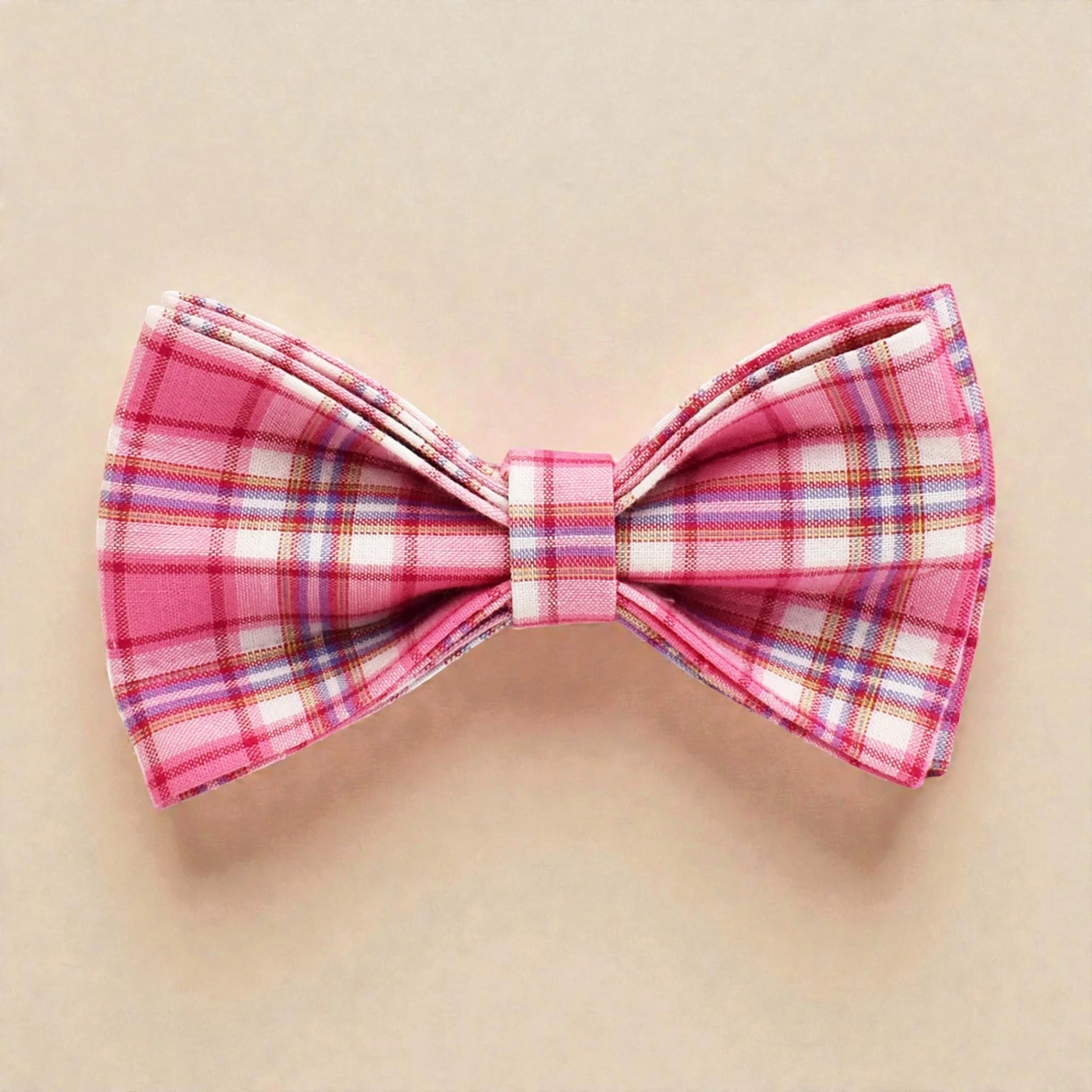 Pink plaid bow tie on a beige background