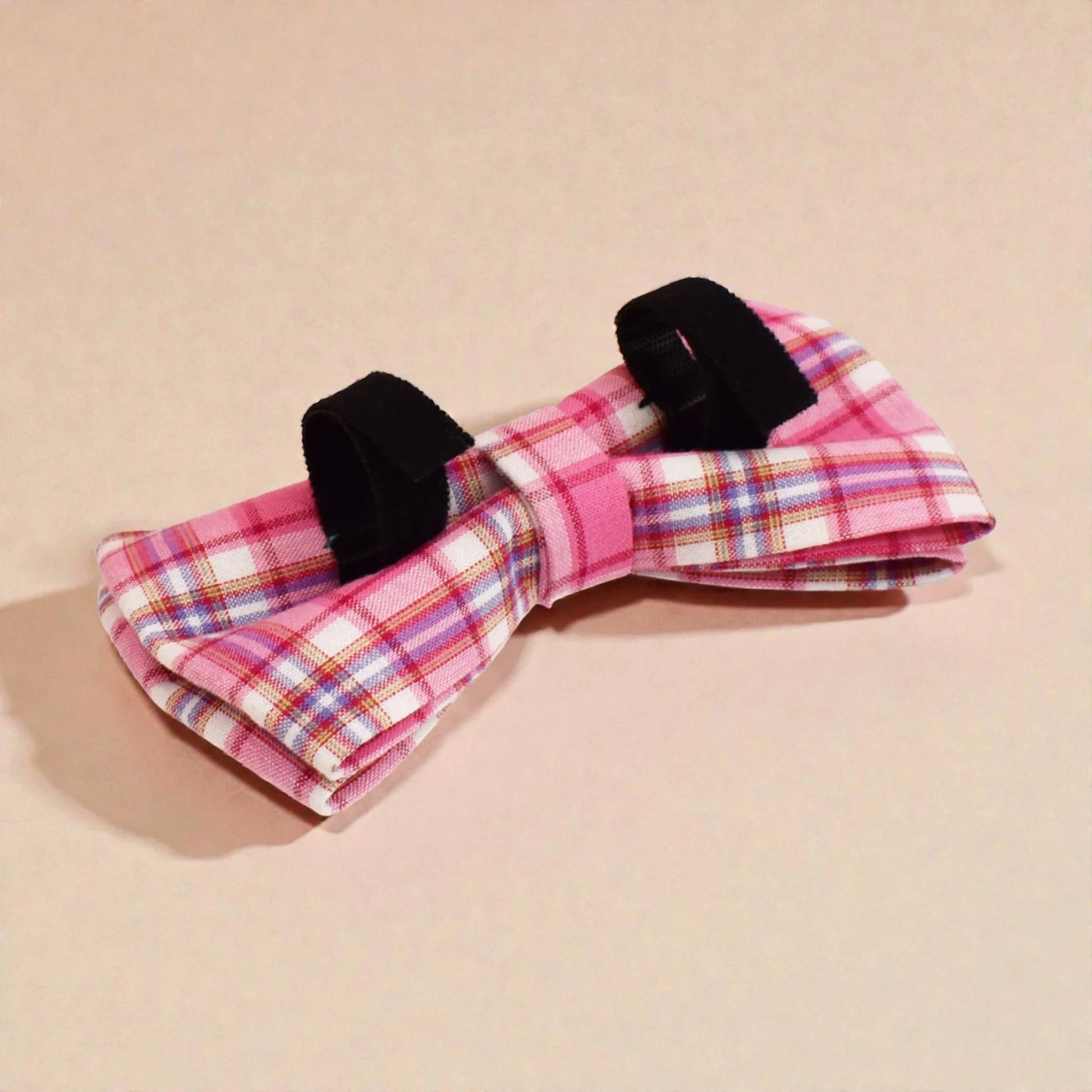 Plaid bow tie with black accents on a beige background