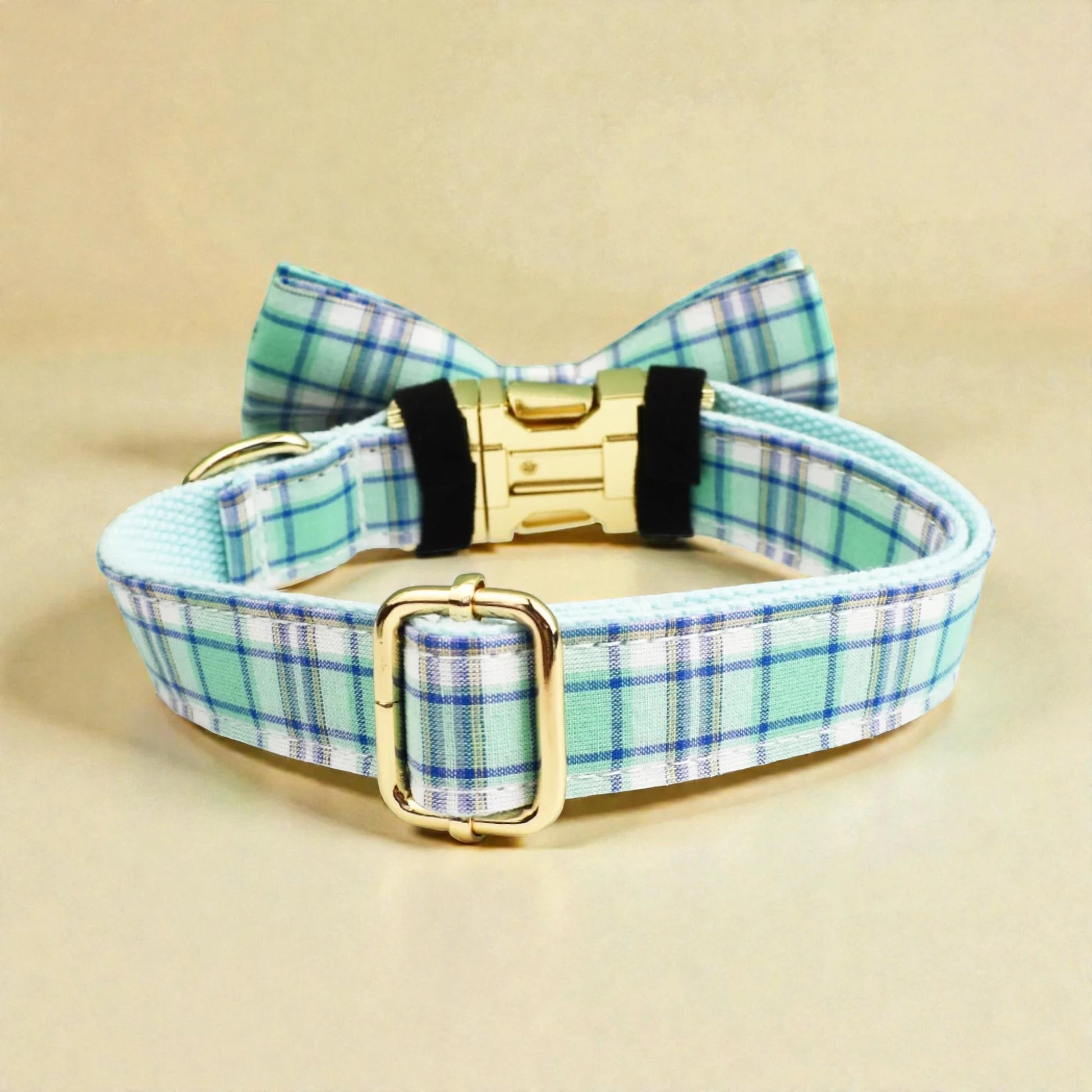 Plaid dog collar in green with a bow tie and gold buckle on a beige background