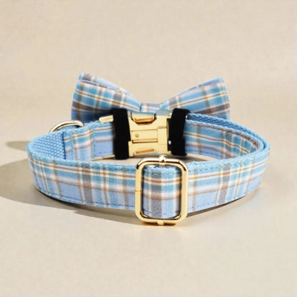 Blue plaid dog collar with a bow tie and gold buckle on a beige background