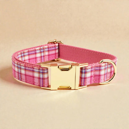 Dog collar with pink plaid pattern and gold buckle on a beige background