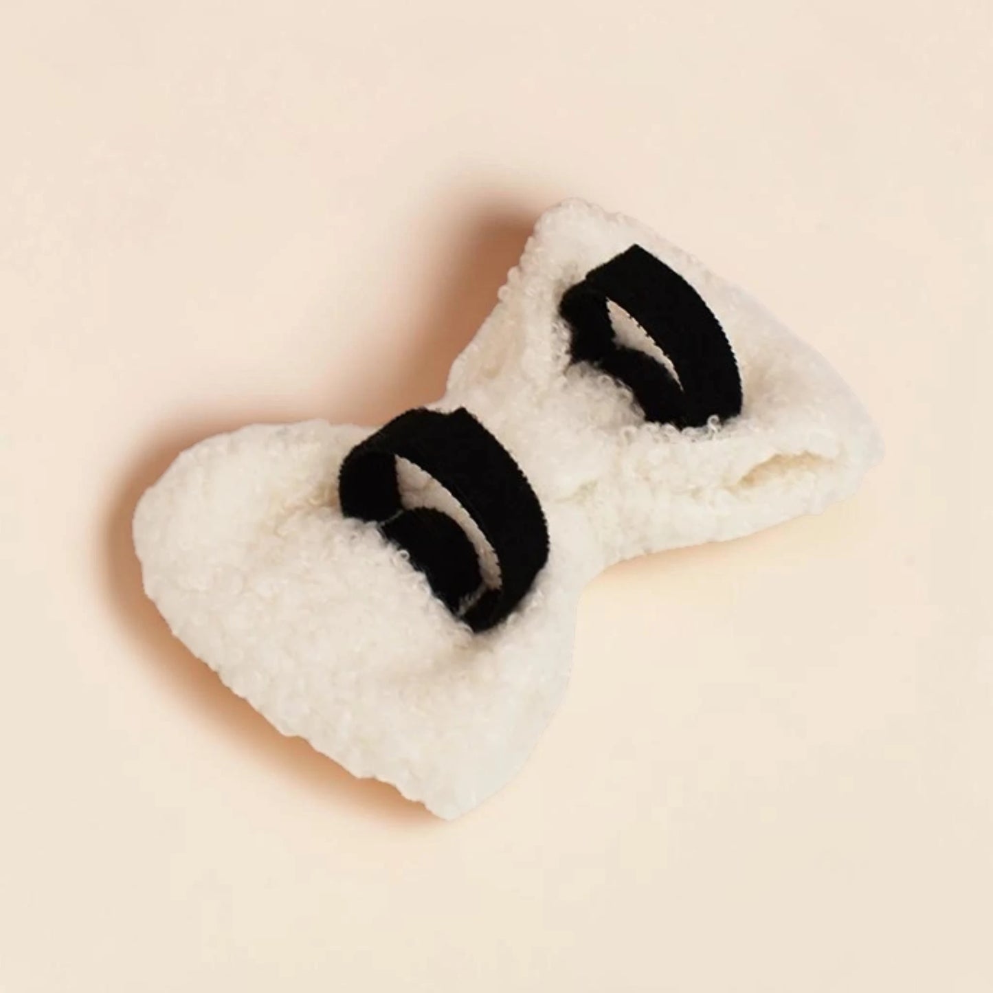 White detachable teddy fleece dog bow on a beige background