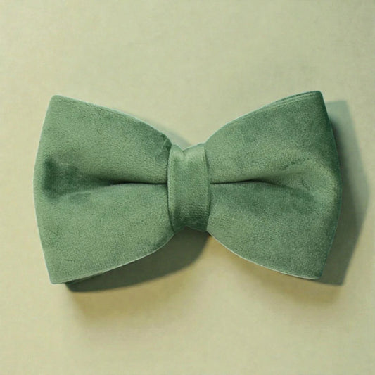 Green bow tie on a beige background