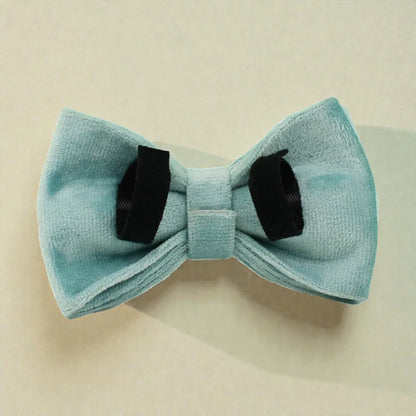 Teal bow tie with black ends on a beige background