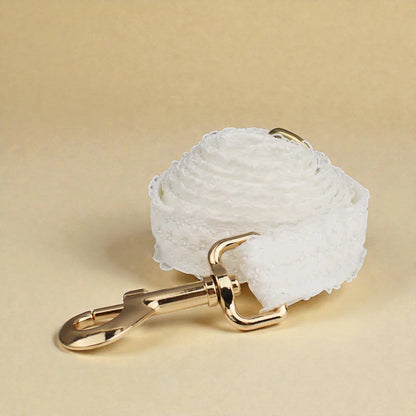 White lace dog lead with a gold clasp on a beige background