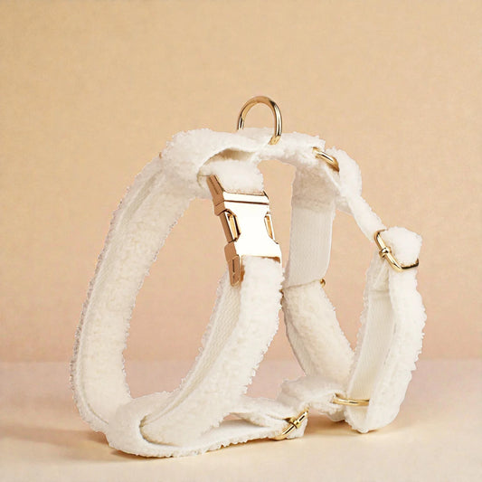 White teddy fleece dog harness with gold hardware on a beige background