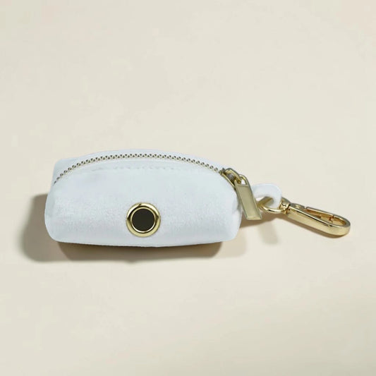 White dog poop bag holder with gold zip and clip on a beige background