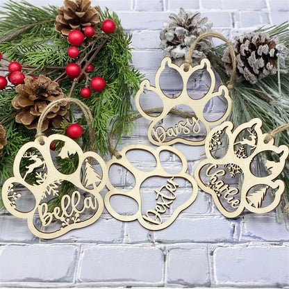 Wooden paw prints with names against a festive background with greenery and pinecones.